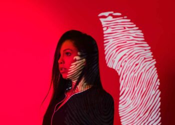 Photo by Cleyton Ewerton: https://www.pexels.com/photo/woman-with-fingerprint-reflection-on-red-background-5063551/