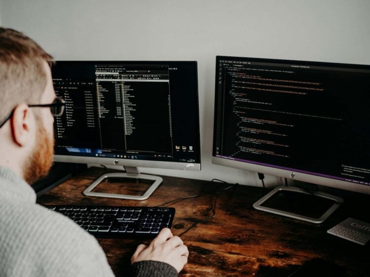 Photo by Lisa Fotios: https://www.pexels.com/photo/man-coding-on-computers-sitting-at-desk-16129703/