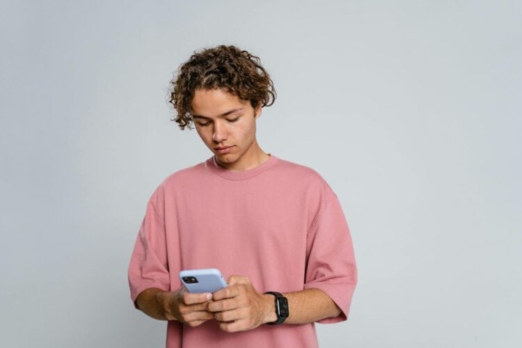Photo by MART PRODUCTION: https://www.pexels.com/photo/man-in-pink-crew-neck-t-shirt-holding-blue-smartphone-9558694/